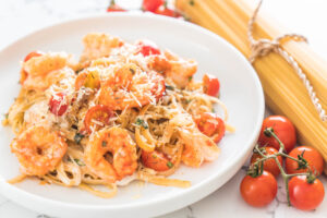 Deliciosos espaguetis con gambas, tomates, albahaca y queso al estilo de la comida italiana.